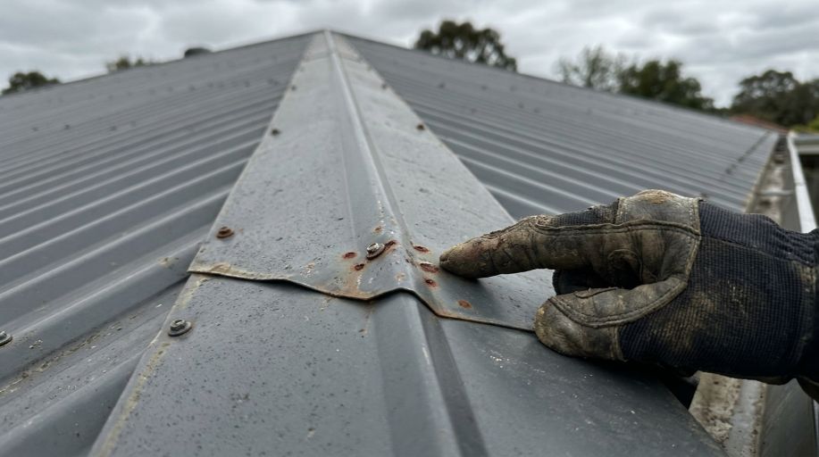 Rust damage on a metal roof requiring professional repair
