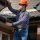 Professional worker measuring height of roof with tape